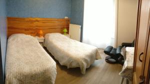 a bedroom with two beds with white blankets at hotel le chatiague in Tence