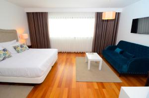 een woonkamer met een bed en een bank bij Casas do Forte do Pico in Funchal +49 foto's