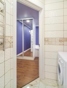 a bathroom with a door leading into a bathroom with purple walls at "Indigo" in Kharkiv