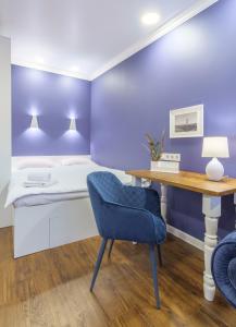 een slaapkamer met een bed en een bureau met een blauwe muur bij "Indigo" in Charkov