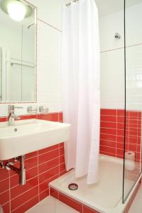 a bathroom with a sink and a shower at Stadthotel Langenfeld in Langenfeld