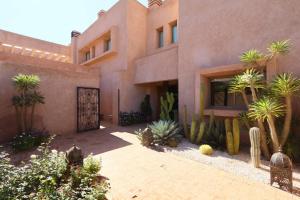 a house with a courtyard with palm trees and a gate at Villa Firdaous in Marrakesh