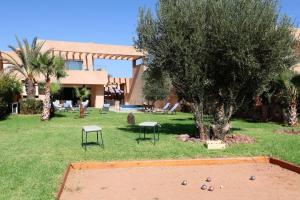 un edificio con un patio con un árbol y una cama elástica en Villa Firdaous, en Marrakech