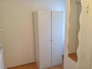 une armoire blanche dans l'angle d'une pièce dans l'établissement Apartment Sophie Olomouc, à Olomouc