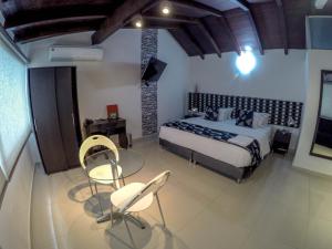 a room with a bed, a chair and a lamp at La Cabrera Hotel Boutique in Neiva