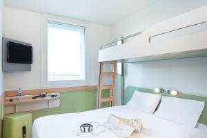 a bedroom with a bunk bed with a ladder at Ibis Budget Salzburg Airport - Contactless Check-In in Salzburg