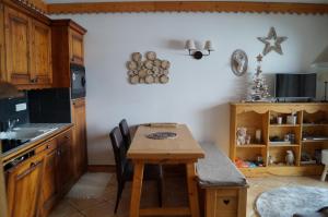 una cucina con tavolo in legno e una sala da pranzo di Myplagne les hauts bois a Aime La Plagne