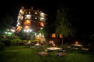 un edificio con mesas y sillas en el patio por la noche en Royal Astoria Hotel, en Katmandú