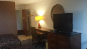 a hotel room with a desk and a television at Audrey's Motel in Mound City