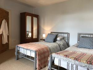 una camera con due letti e uno specchio di Cilwen Country House Bed and Breakfast ad Abernant