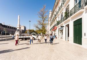 a group of people walking down a city street at FLH Restauradores Amazing Flat with View in Lisbon