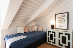 a bedroom with a blue bed in a attic at FLH Restauradores Amazing Flat with View in Lisbon