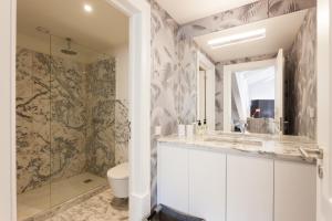 a bathroom with a toilet and a glass shower at FLH Restauradores Amazing Flat with View in Lisbon +10 photos