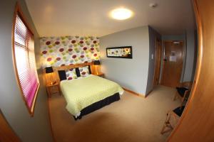a bedroom with a bed and a mirror at Orcades Hostel in Kirkwall