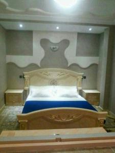 um quarto com uma cama grande e um cobertor azul em appartement Annakhil em Marrakech