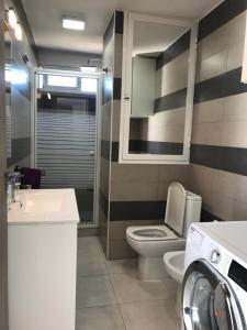 a bathroom with a toilet and a sink and a washing machine at First line Apartment in Alicante