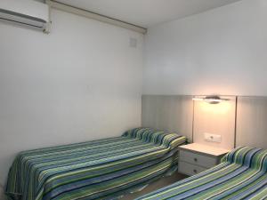 two twin beds in a small room with at First line Apartment in Alicante