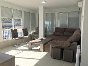 a living room with a couch and a table at First line Apartment in Alicante