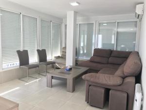 a living room with a couch and chairs and a table at First line Apartment in Alicante