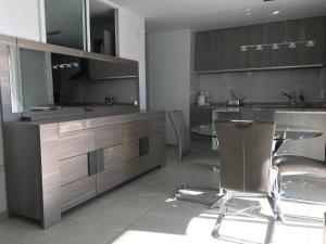 a kitchen with a table and some chairs in it at First line Apartment in Alicante