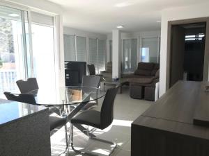 a living room with a glass table and chairs at First line Apartment in Alicante