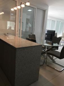 an office with a counter with chairs and a desk at First line Apartment in Alicante