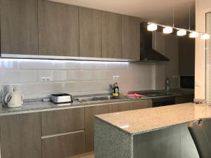 - une cuisine avec des placards en bois et un comptoir dans l'établissement First line Apartment, à Alicante