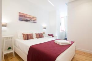 a bedroom with a white bed with a red blanket at MyStay Porto Centro in Porto