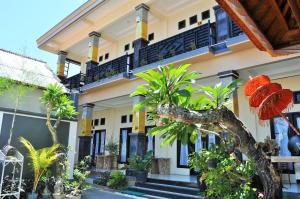 a building with trees and plants in front of it at Deva Devi Beach Inn Luxury in Nusa Penida