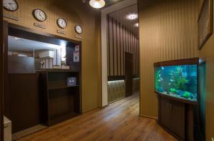 a hallway with a fish tank and clocks on the wall at Soprano Apart Hotel in Odesa