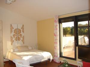 um quarto com uma cama e uma janela com uma varanda em Loft El Carmen em Teruel
