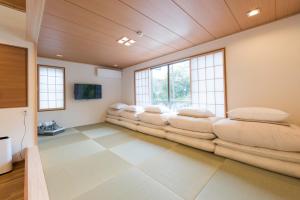 a living room with a bunch of chairs in a room at Guest Villa Hakone Miyanoshita in Hakone