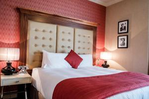 a bedroom with a large bed and two lamps on tables at The Drayton Court Hotel in London