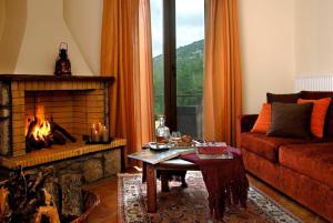 a living room with a fireplace and a couch at Dryas Guesthouse in Polydrossos