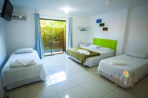 een kamer met twee bedden en een raam bij Pousada Maravilha de Paraty in Paraty +37 foto's