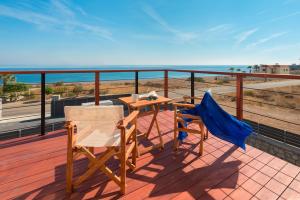 einen Tisch und zwei Stühle auf einem Balkon mit Meerblick in der Unterkunft Southrock Villas in Lachania