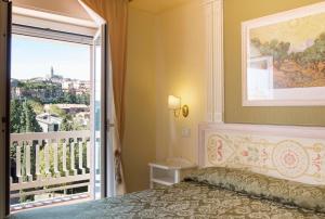 1 dormitorio con 1 cama y balcón en Hotel Tuder, en Todi