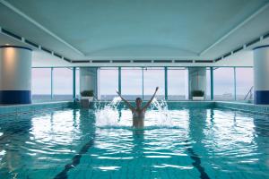 una donna in acqua in una piscina di Hotel Neptun a Warnemünde