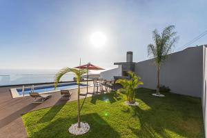 a backyard with a view of the ocean at Searenity Vacation Home I by An Island Apart in Arco da Calheta