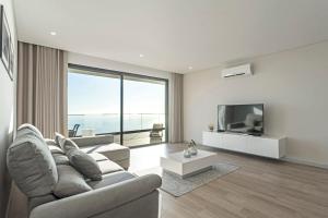 a living room with a couch and a tv at Searenity Vacation Home I by An Island Apart in Arco da Calheta
