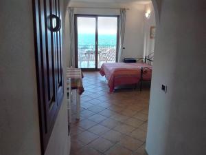 1 dormitorio con cama y vistas al océano en Splendido mono vista mare con wi fi a 100 mt da spiaggia, en Santa Teresa Gallura