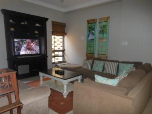 ein Wohnzimmer mit einem Sofa und einem TV in der Unterkunft 1 Marichel in Ballito