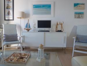 a living room with a desk with a computer and two chairs at Apartamento Casita del Mar in Arrieta