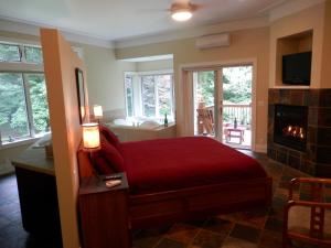 a bedroom with a red bed and a fireplace at Pigeon Creek Inn - Adults Only in Holland