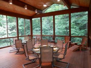 a screened in porch with tables and chairs at Pigeon Creek Inn - Adults Only in Holland