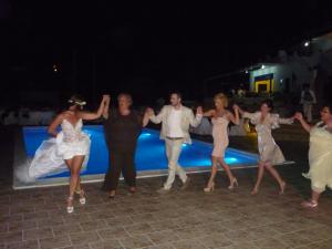 a group of people dancing in front of a pool at Studios Avra in Akhladherí +85 photos