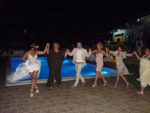 a group of people dancing in front of a pool at Studios Avra in Akhladherí