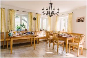 een eetkamer met een tafel en stoelen en een kroonluchter bij Gästehaus Niedermeierhof in Ebersberg