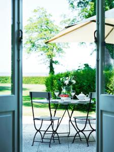 a table with two chairs and an umbrella at Hotel Frederiksminde in Præstø