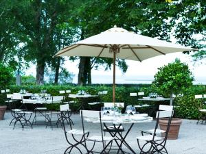 a table with an umbrella and some chairs and tables with tablesearcher at Hotel Frederiksminde in Præstø